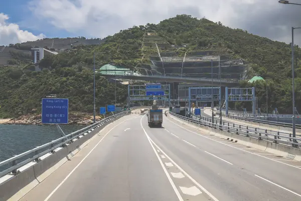 Temiz asfalt şeritli ve yeşil yapraklı yüksek bir yol.