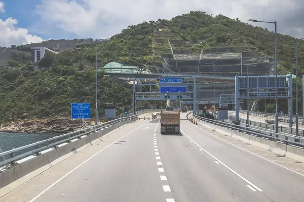 Temiz asfalt şeritli ve yeşil yapraklı yüksek bir yol.