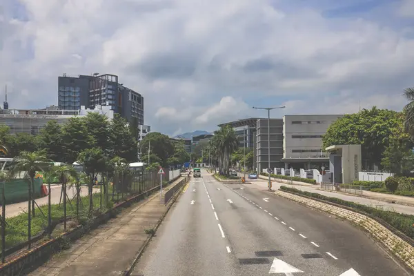 Yüksek binalarla çevrili sakin bir şehir yolu.