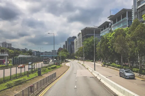 Yüksek binalarla çevrili sakin bir şehir yolu.