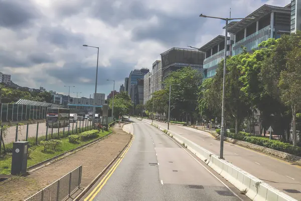 Yüksek binalarla çevrili sakin bir şehir yolu.