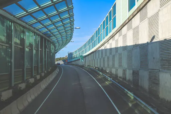 Çağdaş üstgeçit yapılarıyla çevrili kıvrımlı kentsel yol camlı.