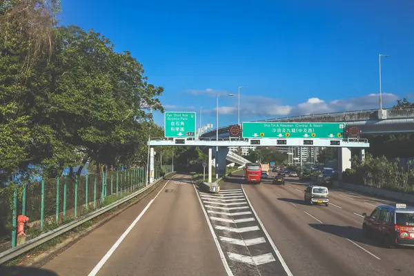 açık mavi gökyüzünün altındaki ağaçların ve binaların arka planı. Canlı bir şehirde güneşli bir günde, şehir içi gidip gelen yaşam tarzını yakalar..
