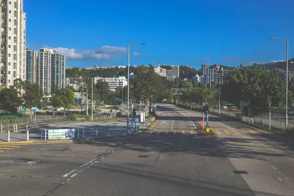 Yol, kaldırımlar, ağaçlar içeren temiz şehir manzarası,