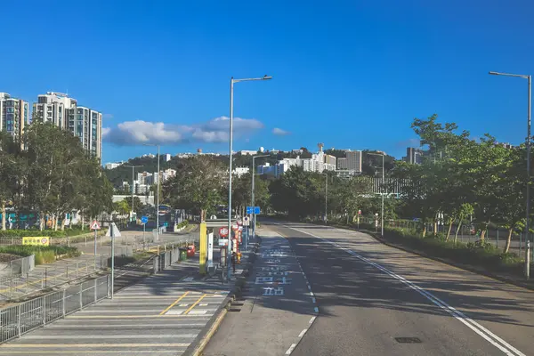 Yol, kaldırımlar, ağaçlar içeren temiz şehir manzarası,