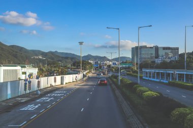 Yeşil ve uzak dağlarla çevrili açık bir şehir yolu.,