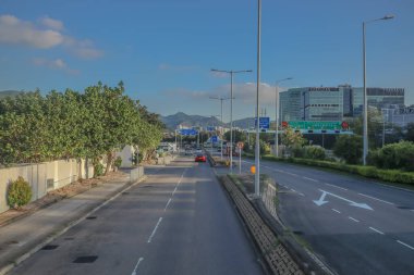 Yeşil ve uzak dağlarla çevrili açık bir şehir yolu.,