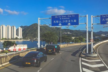 Şehir kavşağı trafiği, şehir silüeti ve güneşli bir havanın altındaki dağlar