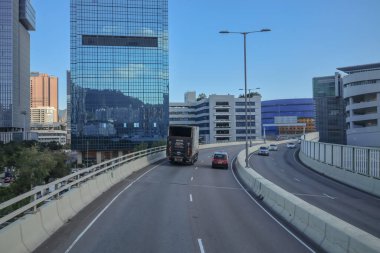 Mavi muşambaya sarılı bir inşaat alanını gösteren bir şehir manzarası.