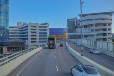 Mavi muşambaya sarılı bir inşaat alanını gösteren bir şehir manzarası.