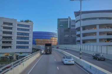 Mavi muşambaya sarılı bir inşaat alanını gösteren bir şehir manzarası.