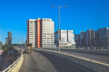 Modern gökdelenlerin ve benzersiz gökdelenlerin kuşattığı bir şehir otoyolu manzarası