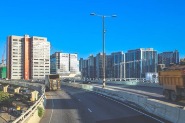 Modern gökdelenlerin ve benzersiz gökdelenlerin kuşattığı bir şehir otoyolu manzarası