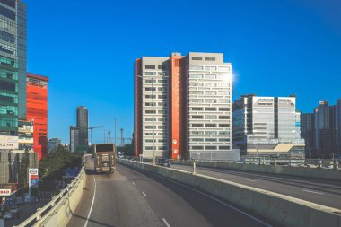 Modern gökdelenlerin ve benzersiz gökdelenlerin kuşattığı bir şehir otoyolu manzarası