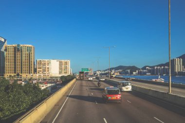 Bir kıyı şehrine doğru giden işlek bir şehir otoyolu manzarası,