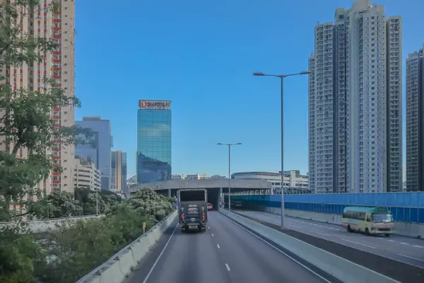 Mavi muşambaya sarılı bir inşaat alanını gösteren bir şehir manzarası.