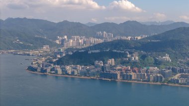 Yeşil tepenin arasına kurulmuş modern bir sahil kenti sergileniyor.