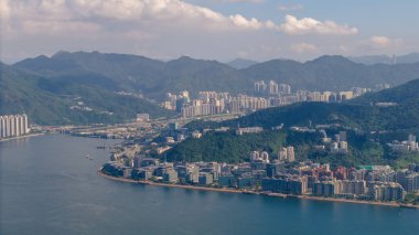 Yeşil bir tepenin yer aldığı pitoresk bir şehir manzarası