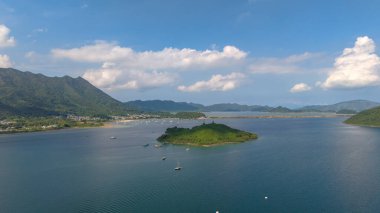 Etrafı yemyeşil dağlarla çevrili sakin bir sahil şeridi sergileniyor.