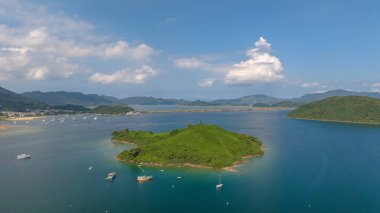 Etrafı yemyeşil dağlarla çevrili sakin bir sahil şeridi sergileniyor.