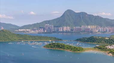 Yeşil adaları, yatları olan sakin bir kıyı manzarası.