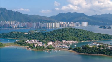 Yeşil adaları, yatları olan sakin bir kıyı manzarası.