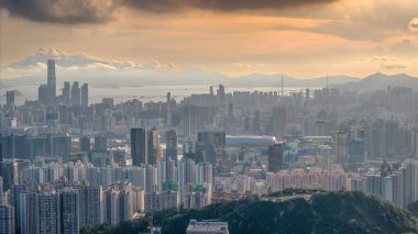 Modern binalar ve pitoresk bir gün batımının yer aldığı bir şehir silüeti.