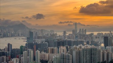 Modern binalar ve pitoresk bir gün batımının yer aldığı bir şehir silüeti.