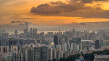 Modern binalar ve pitoresk bir gün batımının yer aldığı bir şehir silüeti.