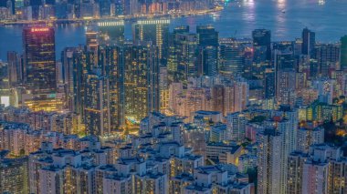 Parlak ışıklandırılmış gökdelenler ve kentsel mahallelerin olduğu canlı şehir manzarası