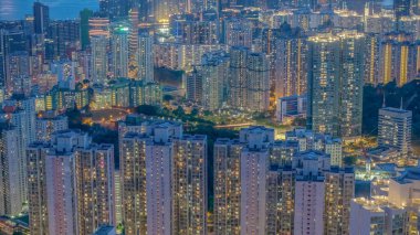 Parlak ışıklandırılmış gökdelenler ve kentsel mahallelerin olduğu canlı şehir manzarası