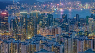 Parlak ışıklandırılmış gökdelenler ve kentsel mahallelerin olduğu canlı şehir manzarası