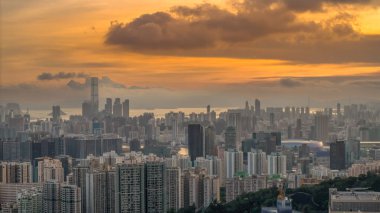 Modern binalar ve pitoresk bir gün batımının yer aldığı bir şehir silüeti.