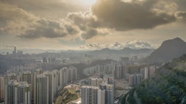 Modern binalar ve pitoresk bir gün batımının yer aldığı bir şehir silüeti.