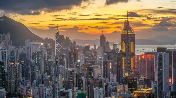 Gün batımında Hong Kong 'un aydınlık gökdelenleri canlı şehirleri gösteriyor.