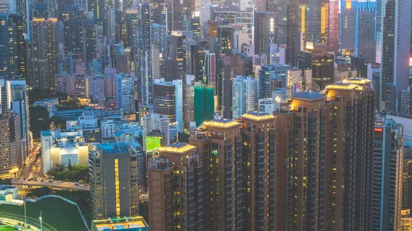 Alacakaranlık gökyüzüne karşı aydınlatılmış gökdelenleri barındıran şehir manzarası