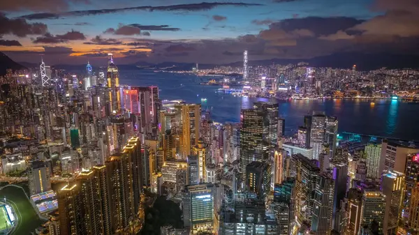 Alacakaranlık sırasında şehir silüeti, aydınlık gökdelenleri gösteriyor,