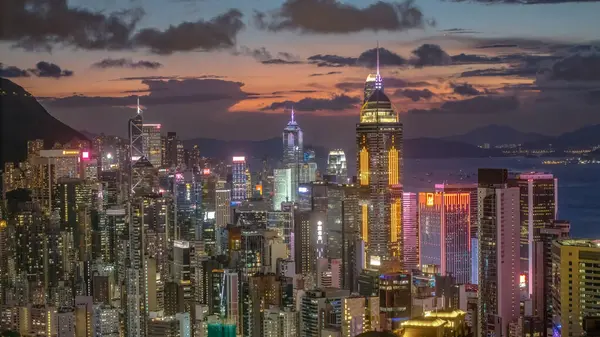 Gün batımında Hong Kong 'un aydınlık gökdelenleri canlı şehirleri gösteriyor.