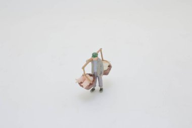 Sepetlerde eşya taşıyan birini tasvir eden küçük bir heykel.