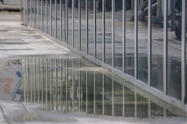 Çevresini yansıtan bir binanın modern cam cephesi