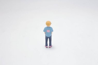 Gülen yüz maskesi takan küçük bir heykel bir düzlükte duruyor.