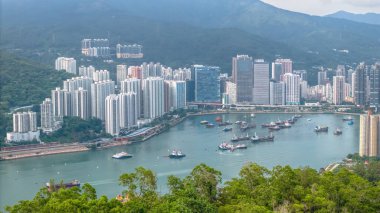 Huzurlu bir limanın yanındaki yüksek binaların yer aldığı geniş şehir manzarası