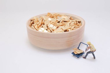 Minyatür işçi figürünün ittiği kavramsal bir görüntü.