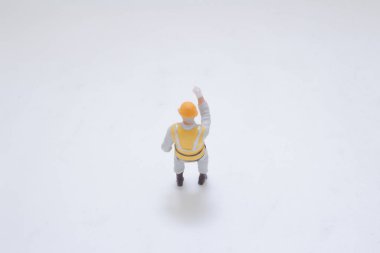 Emniyet kilidi takan küçük ölçekli bir inşaat işçisi figürü.