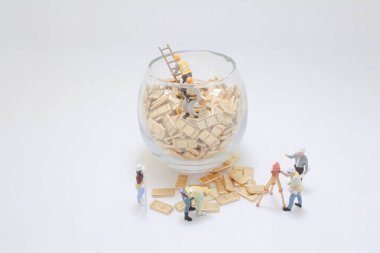 Altın külçelerle etkileşen minyatür figürlerin yer aldığı yaratıcı kavramsal bir resim