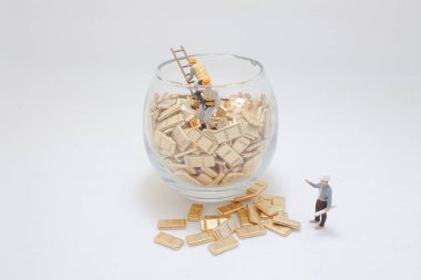 Altın külçelerle etkileşen minyatür figürlerin yer aldığı yaratıcı kavramsal bir resim