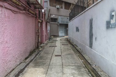 Pembe ve beyaz desenli duvarları olan tenha, dar bir sokak.