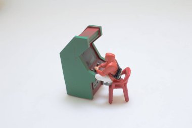 Kırmızı giysili biblo yeşil bir atari makinesiyle bağlanıyor,