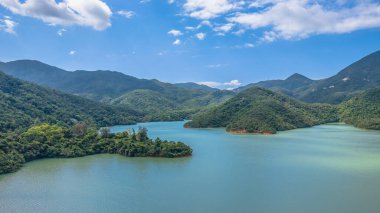 Bereketli yeşil tepelerle çevrili sakin bir su deposu.