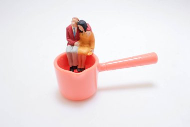 Oturan erkek ve kadının küçük heykellerinin büyüleyici bir tasviri.